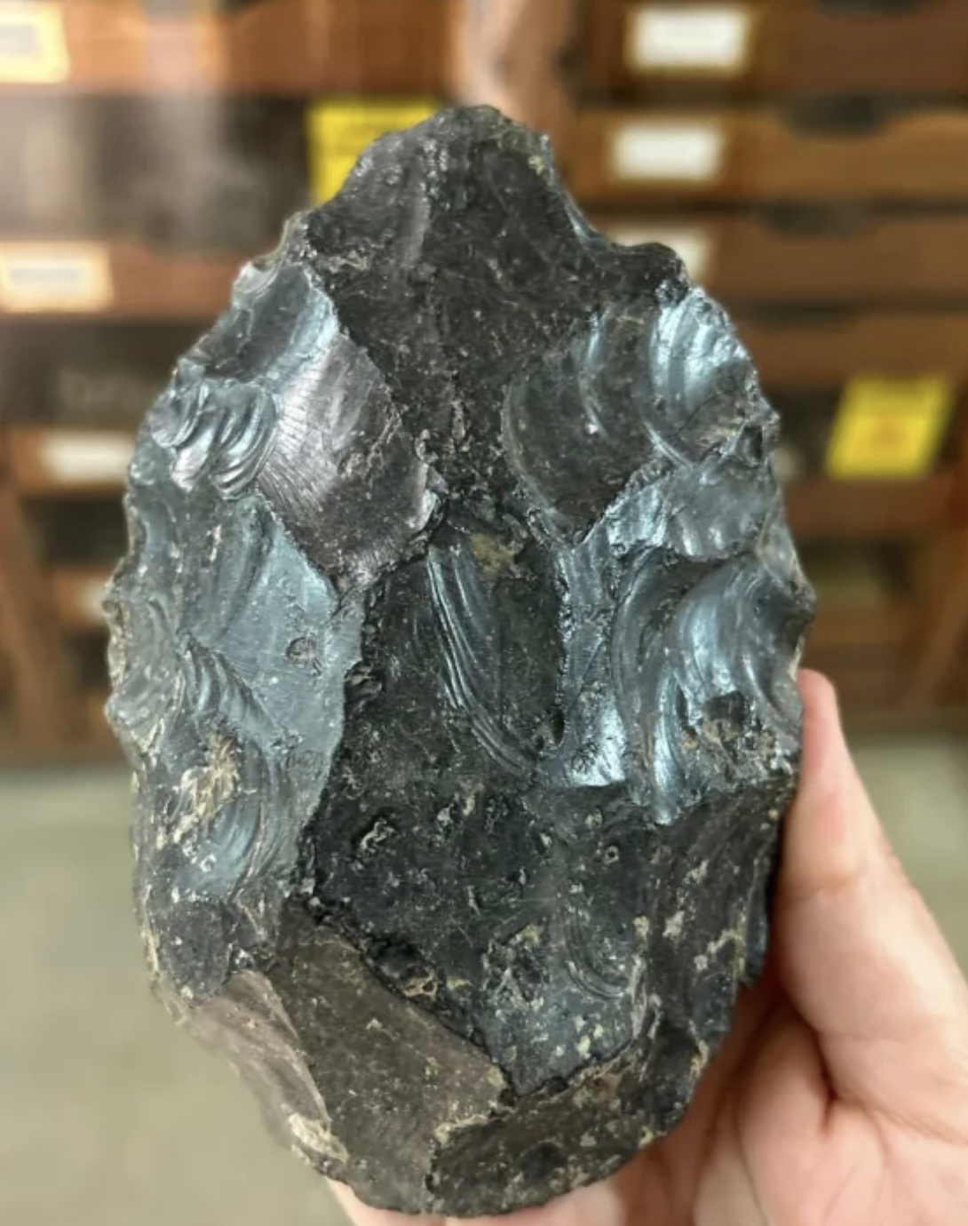 A researchers holds on of the obsidian handaxes found at the site.
